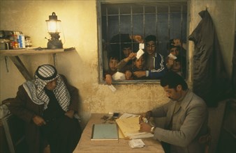PALESTINE, West Bank, PLO camp or Gamstation.  Boys looking through barred window.