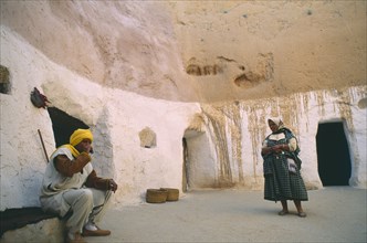 TUNISIA, Matmata, Couple at entrance to cave homes.