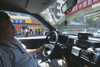 CHINA, Yunnan, Kunming , Interior of a taxi with view from passenger seat towards the driver.
