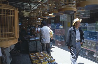 CHINA, Yunnan , Kunming, A man wearing a hat walking through a alley way in a Bird and Flower