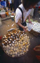 CHINA, Yunnan, Kunming, Covered food market  with baskets filled with thousand year old eggs.