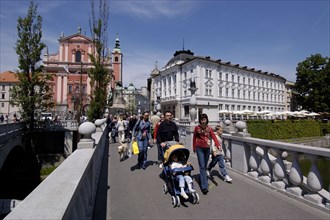 SLOVENIA, Ljubljana, View along the Triple Bridge in the city centre with pedestrians crossing