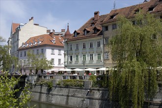 SLOVENIA, Ljubljana, River Ljubljanica. View along row of riverside cafes toward the old town