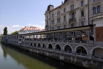 SLOVENIA, Ljubljana, River Ljubljanica. View along embankment and colonnade designed by Joze