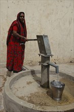 INDIA, Rajasthan, Jaipur, Woman filling bucket at Tara water pump
