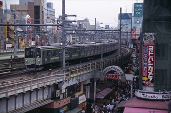 JAPAN, Honshu, Tokyo, Train travelling along the elevated tracks above the Ameyayokocho market