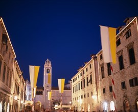 CROATIA, Dalmatia, Dubrovnik, View along the Stradun toward the clocktower with Vatican flags for