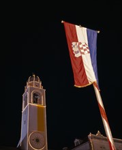 CROATIA, Dalmatia, Dubrovnik, View looking up at the Clocktower illuminated at night with Croatian