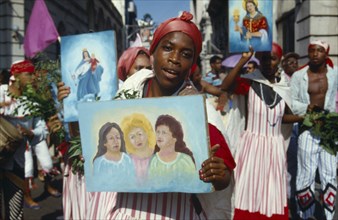 CUBA, Santiago de Cuba, Woman holding religious imagery at a festival