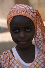 NIGERIA, Kano, Portrait of girl wearing orange headscarf