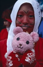JAPAN, Honshu, Tokyo, Harajuku District. Portrait of young teenage girl wearing red face paint and
