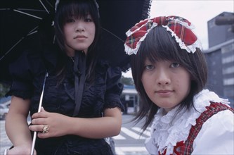 JAPAN, Honshu, Tokyo, Harajuku District. Portrait of two young teenage girls with one wearing black