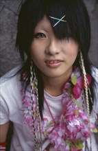 JAPAN, Honshu, Tokyo, Harajuku District. Portrait of a teenage girl wearing a flower garland and