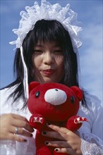 JAPAN, Honshu, Tokyo, Harajuku District. Portrait of a teenage girl wearing white lace dress