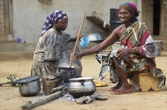 GHANA, Cooking, "Women cooking banku a fermented corn and cassava dough cooked to a paste in hot