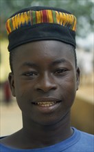 GHANA, Tribal People, Portrait of boy wearing hat made from traditional kente cloth.