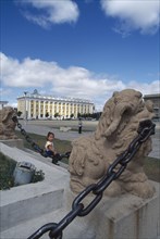 MONGOLIA, Ulan Bator, Sukhbaatar square with small girl sitting on chainlink fence around steps in