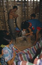LAOS, Markets, Hmong village.  Building interior with people making rice balls.