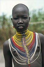 SUDAN, Body Decoration, "Young Dinka girl wearing multi stranded necklace made from tiny yellow,