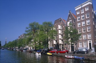 HOLLAND, Noord, Amsterdam, View along the canal lined with traditional architecture and trees