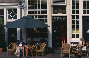 HOLLAND, Noord, Amsterdam, Brown Cafe facade with couple sitting outside