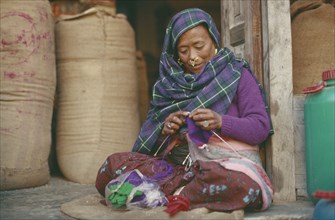 NEPAL, Gorkha Bazaar, Magar woman knitting
