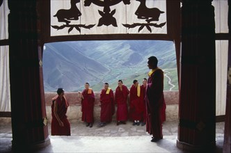CHINA, Tibet, Gandeh Monastery, Monks on the balcony overlooking the valley below