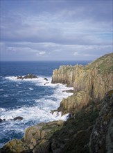 ENGLAND, Cornwall, Lands End, Waves breaking against eroded sea cliffs in winter.