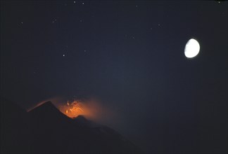 ITALY, Aeolian Islands, Stromboli, Night view of the active volcano hourly eruption with moon