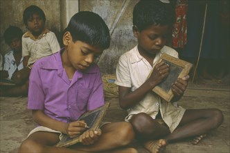 INDIA, Gudullur Hills, Education, Tribal boys at rural school writing on slates.