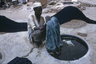 NIGERIA, Kano, Man working in the indigo dye pits