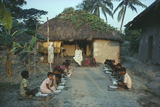 INDIA, West Bengal, Pathasala, Outdoor informal school. Pupils seated in two lines facing each