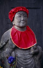 JAPAN, Honshu, Kamakura, Jizo statue traditionally dressed in red bibs by bereaved mothers and