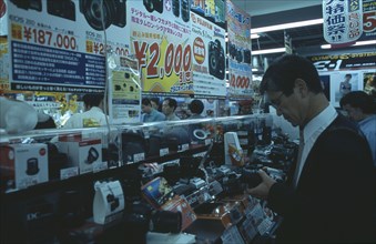 JAPAN, Honshu, Tokyo, Shinjuku. Customers browsing in busy Camera shop interior
