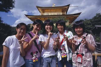 JAPAN, Honshu, Kyoto, Group of teenage girls standing in front of the Kinkaku Ji aka Golden