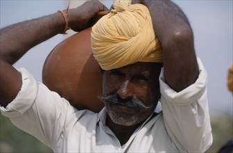 INDIA, Rajasthan, Thar Desert, Bhansda Village.  Portrait of desert man wearing yellow turban and