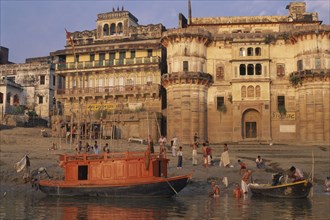 INDIA, Uttar Pradesh, Varanasi, Boats and ritual bathers on the ghats at dawn.