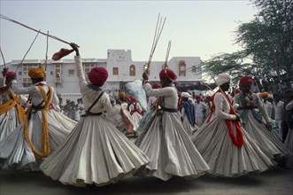 INDIA, Rajasthan, Jodhpur, Men in traditional clothes performing dance for the Maharaja of Jodhpur