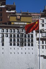 TIBET, Lhasa, The Potala Palace with a red Chinese flag flying in front.