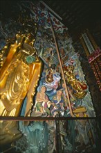 CHINA, Yunnan, Kunming, Golden statuary inside Huating Temple.