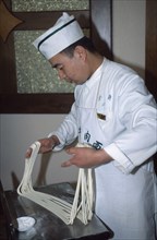 CHINA, Gansu, Lanzhou. A cook demonstrating how to make noodles by hand.