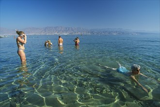 ISRAEL, Eilat, Coral Beach.  Swimmers on Red Sea coast resort.