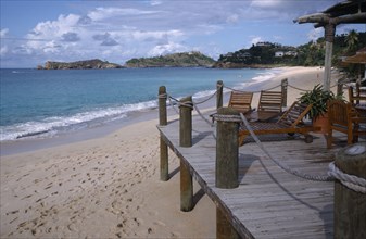 WEST INDIES, Antigua, Galley Bay, View along the beach from a wooden hotel beach terrace