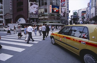 JAPAN, Honshu, Tokyo, Ginza. Pedestrian crossing with taxi cab in the foreground