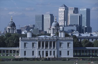 ENGLAND, London, Greenwich. View over lawn toward Queens House with the Canary Wharf skyline beyond