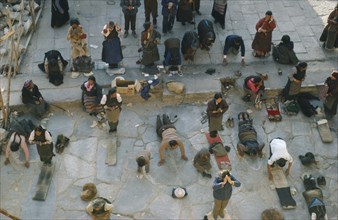TIBET, Lhasa, Jokhang Monastery, Pilgrims prostrate themselves and pray in front of Jokhang