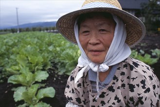 JAPAN, Honshu, Densho en, Woman wearing a hat beside vegetable plot