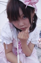 JAPAN, Honshu, Tokyo, Harajuku District. Portrait of young teenage girl wearing pink and white
