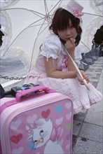 JAPAN, Honshu, Tokyo, Harajuku District. Portrait of young teenage girl wearing a pink and white