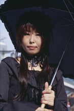 JAPAN, Honshu, Tokyo, Harajuku District. Portrait of a teenage girl dressed in black with a black